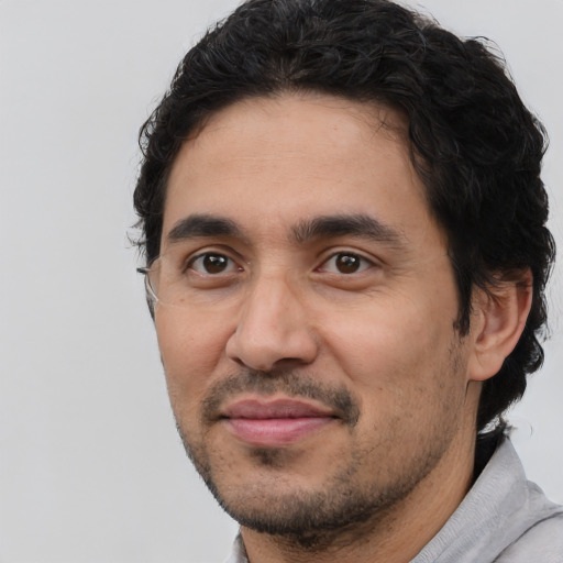Joyful latino young-adult male with short  brown hair and brown eyes