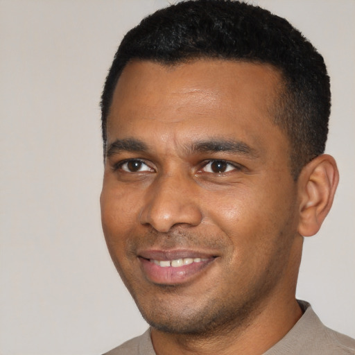 Joyful black young-adult male with short  black hair and brown eyes