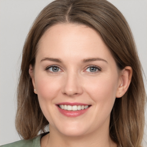 Joyful white young-adult female with long  brown hair and grey eyes