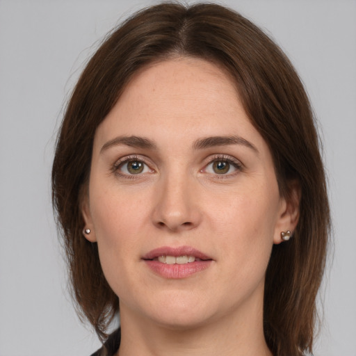 Joyful white young-adult female with medium  brown hair and grey eyes