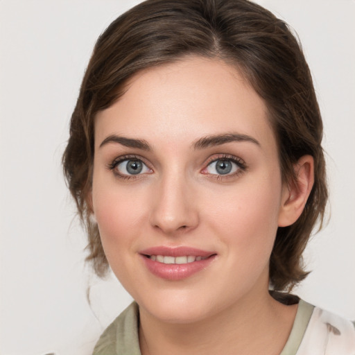 Joyful white young-adult female with medium  brown hair and grey eyes