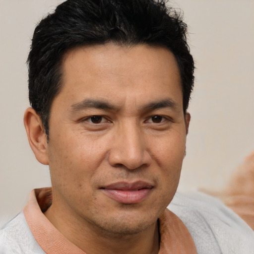 Joyful asian adult male with short  brown hair and brown eyes