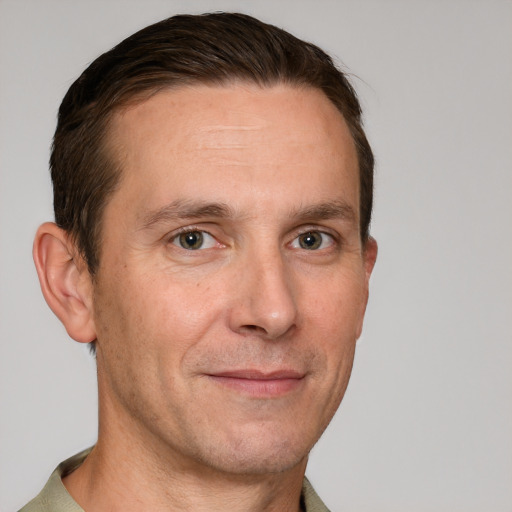 Joyful white adult male with short  brown hair and grey eyes