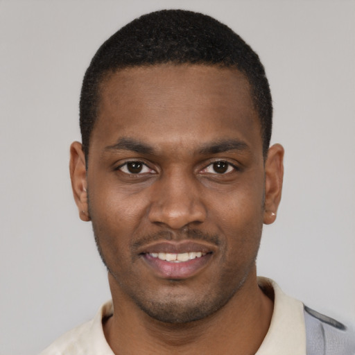 Joyful black young-adult male with short  black hair and brown eyes