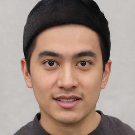 Joyful asian young-adult male with short  black hair and brown eyes