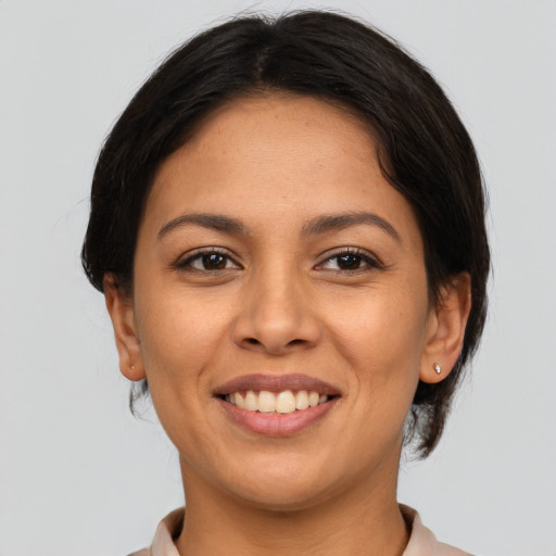 Joyful latino young-adult female with medium  brown hair and brown eyes