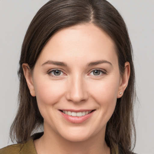 Joyful white young-adult female with medium  brown hair and grey eyes