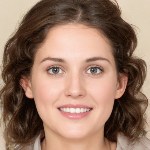 Joyful white young-adult female with medium  brown hair and green eyes