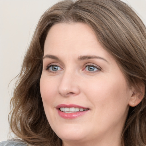 Joyful white young-adult female with medium  brown hair and blue eyes