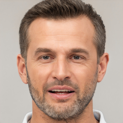 Joyful white adult male with short  brown hair and brown eyes