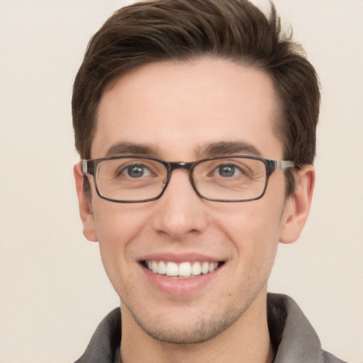 Joyful white young-adult male with short  brown hair and grey eyes