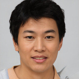 Joyful asian young-adult male with short  brown hair and brown eyes