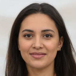 Joyful latino young-adult female with long  brown hair and brown eyes