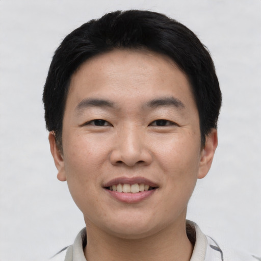 Joyful asian young-adult male with short  black hair and brown eyes