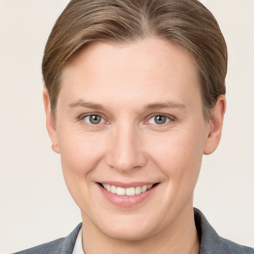 Joyful white young-adult female with short  brown hair and grey eyes