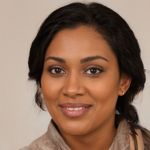 Joyful black young-adult female with long  brown hair and brown eyes