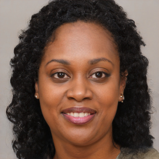 Joyful black young-adult female with long  brown hair and brown eyes