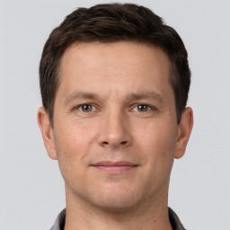 Joyful white young-adult male with short  brown hair and grey eyes