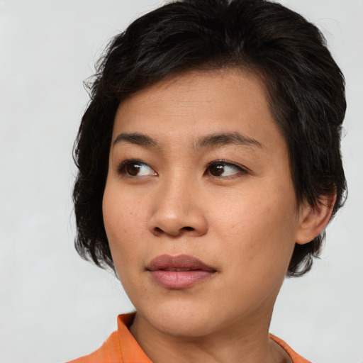 Joyful asian young-adult female with medium  brown hair and brown eyes