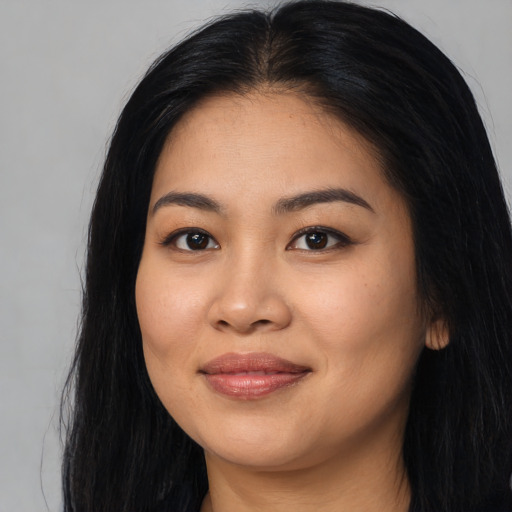 Joyful asian young-adult female with long  black hair and brown eyes