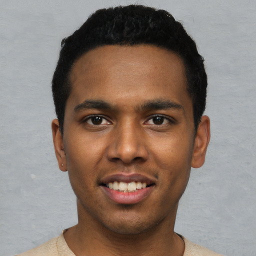 Joyful black young-adult male with short  black hair and brown eyes