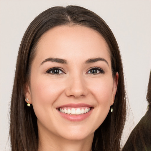 Joyful white young-adult female with long  brown hair and brown eyes