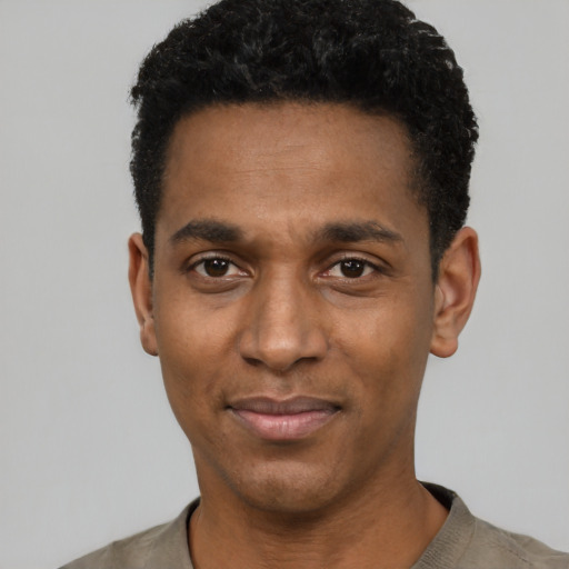 Joyful black young-adult male with short  black hair and brown eyes