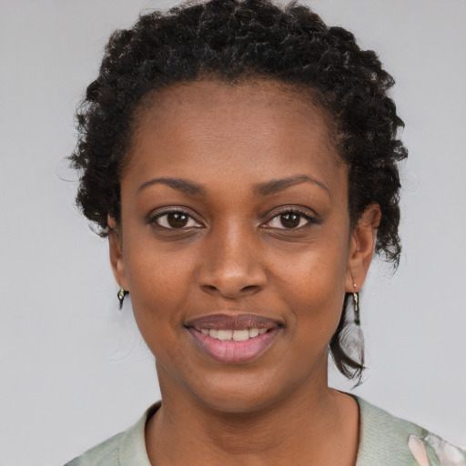 Joyful black young-adult female with short  black hair and brown eyes