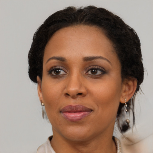 Joyful black adult female with medium  brown hair and brown eyes