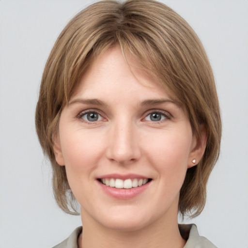 Joyful white young-adult female with medium  brown hair and grey eyes