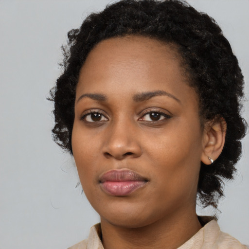 Joyful black young-adult female with long  black hair and brown eyes