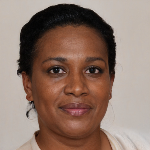Joyful black adult female with short  black hair and brown eyes