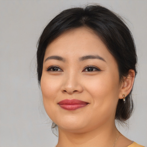 Joyful asian young-adult female with medium  brown hair and brown eyes