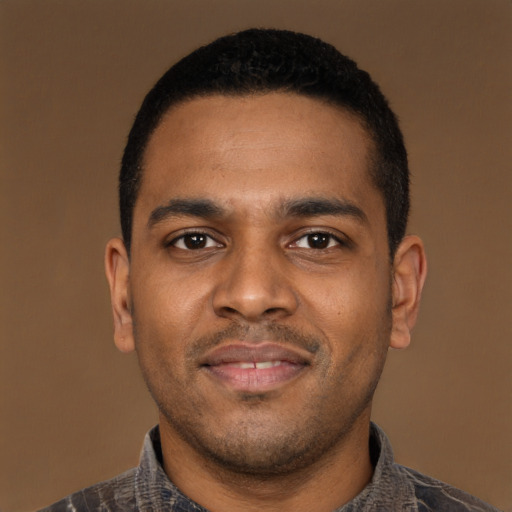 Joyful black young-adult male with short  black hair and brown eyes