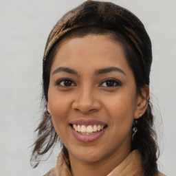 Joyful latino young-adult female with long  brown hair and brown eyes