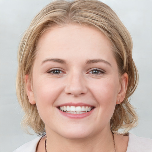 Joyful white young-adult female with medium  brown hair and blue eyes