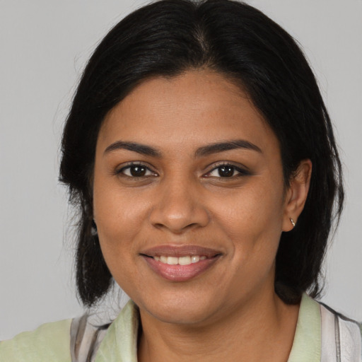 Joyful black young-adult female with medium  brown hair and brown eyes