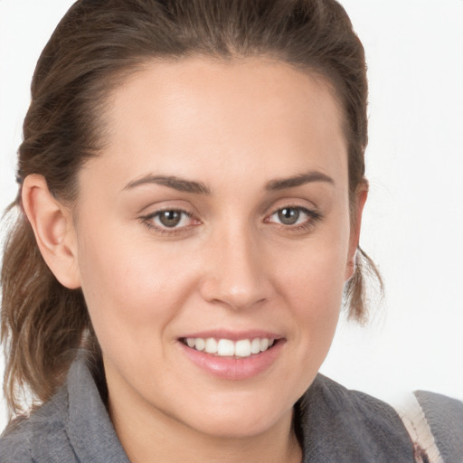 Joyful white young-adult female with medium  brown hair and grey eyes