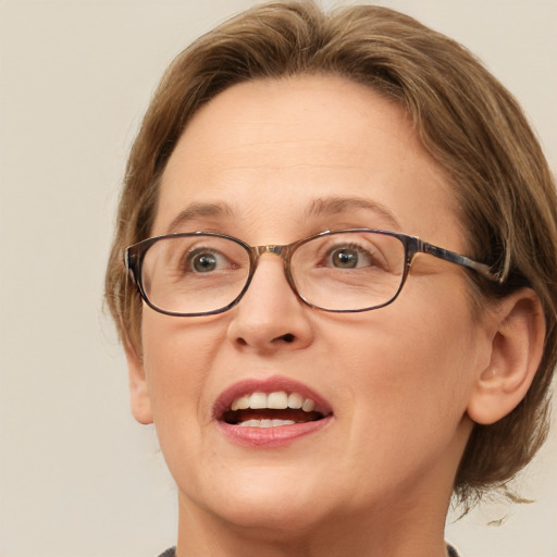 Joyful white adult female with medium  brown hair and green eyes