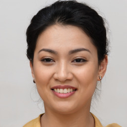 Joyful asian young-adult female with long  brown hair and brown eyes