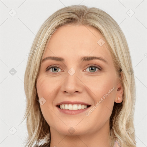 Joyful white young-adult female with long  brown hair and blue eyes