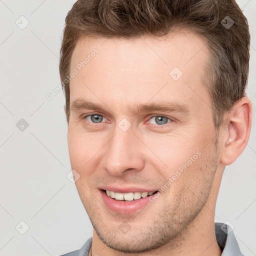 Joyful white young-adult male with short  brown hair and grey eyes