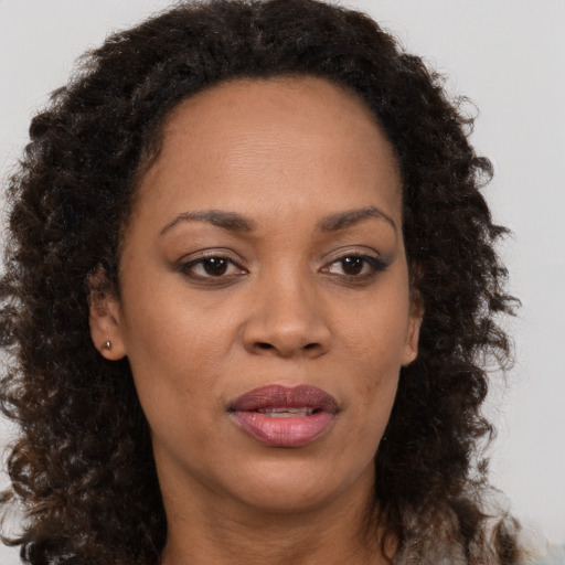 Joyful black adult female with medium  brown hair and brown eyes