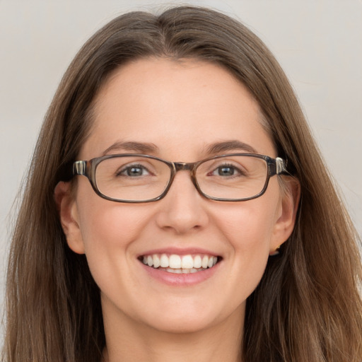 Joyful white adult female with long  brown hair and grey eyes