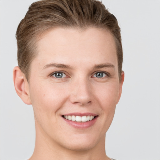 Joyful white young-adult female with short  brown hair and grey eyes