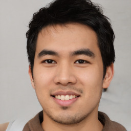 Joyful asian young-adult male with short  black hair and brown eyes