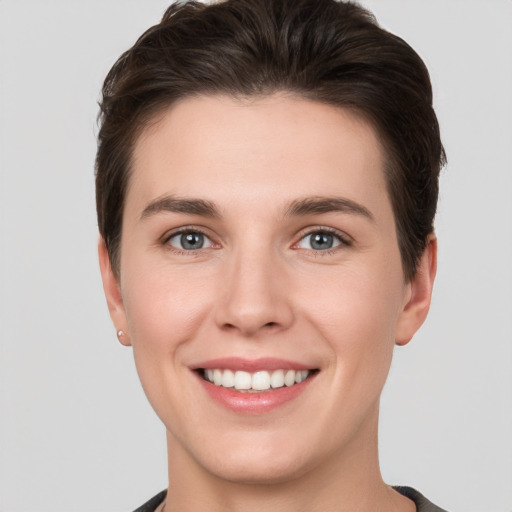 Joyful white young-adult female with short  brown hair and grey eyes