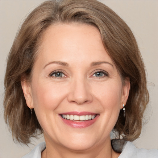 Joyful white adult female with medium  brown hair and brown eyes