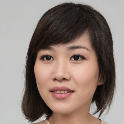 Joyful asian young-adult female with medium  brown hair and brown eyes