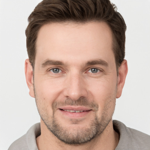 Joyful white young-adult male with short  brown hair and grey eyes